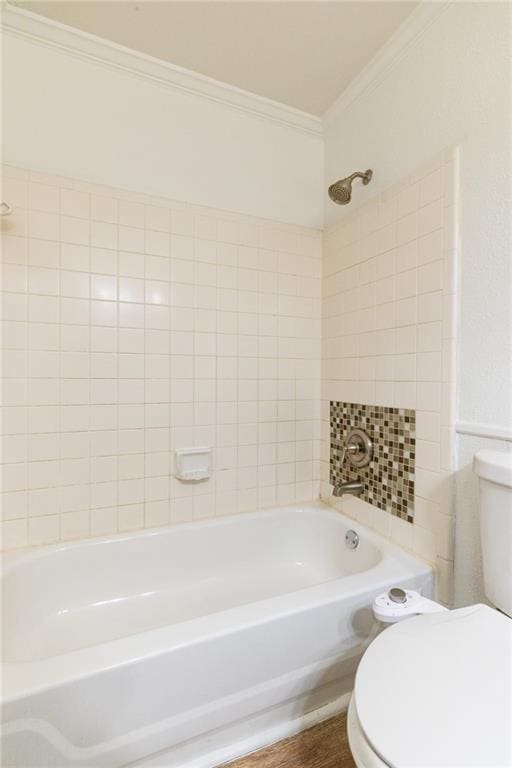 bathroom with toilet, wood-type flooring, crown molding, and tiled shower / bath