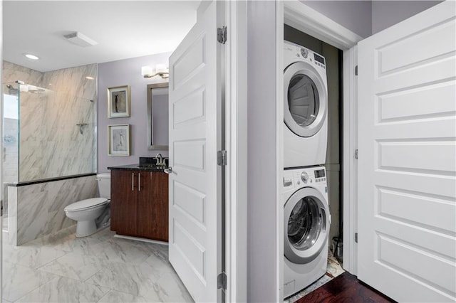 1080 Peachtree St NE Unit 2710, Atlanta, GA 30309 - laundry room with stacked washing machine and dryer and light marble finish flooring
