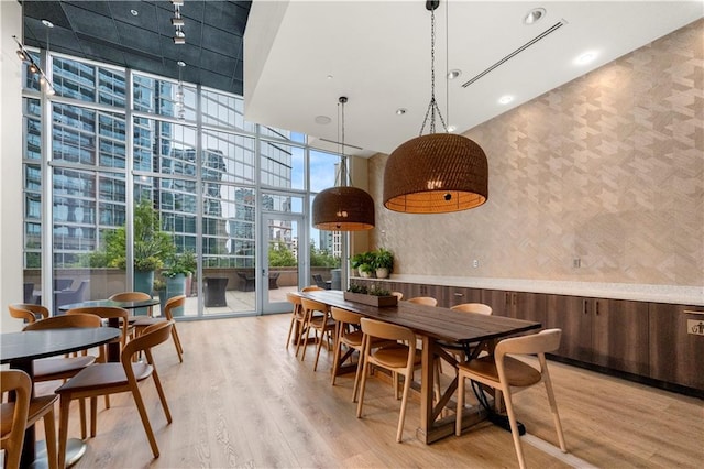 1080 Peachtree St NE Unit 2710, Atlanta, GA 30309 - dining area featuring a wall of windows, a high ceiling, wallpapered walls, wood finished floors, and recessed lighting