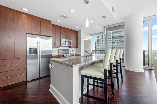 1080 Peachtree St NE Unit 2710, Atlanta, GA 30309 - kitchen featuring stainless steel appliances, dark wood finished floors, a kitchen bar, decorative light fixtures, and recessed lighting