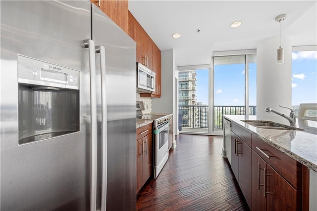 1080 Peachtree St NE Unit 2710, Atlanta, GA 30309 - kitchen with appliances with stainless steel finishes, a wall of windows, dark wood-style flooring, light stone countertops, and brown cabinets