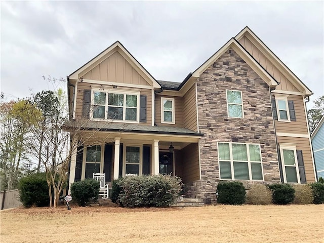 craftsman house featuring stone siding, covered porch, and board and batten siding