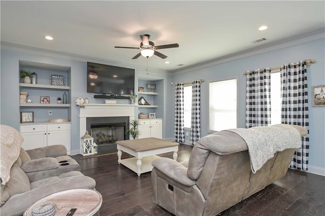 living area featuring a ceiling fan, dark wood-style flooring, and crown molding