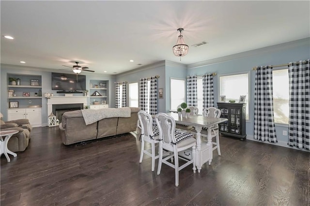 dining room featuring dark wood finished floors, a healthy amount of sunlight, and visible vents