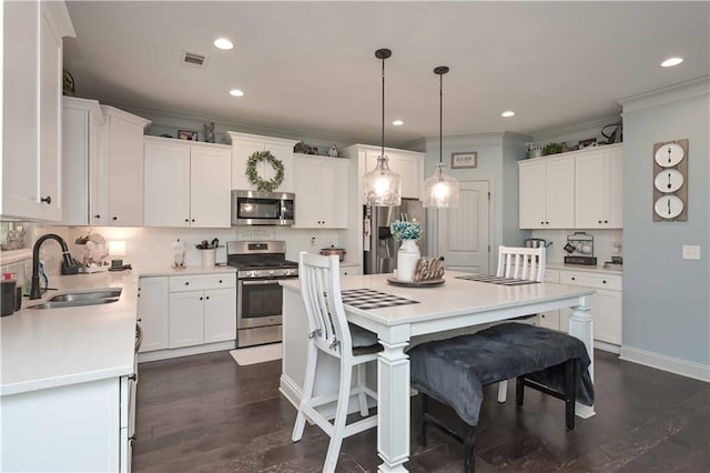 kitchen featuring visible vents, ornamental molding, a sink, appliances with stainless steel finishes, and white cabinets