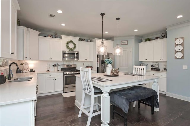 kitchen featuring crown molding, a sink, stainless steel appliances, visible vents, and white cabinets