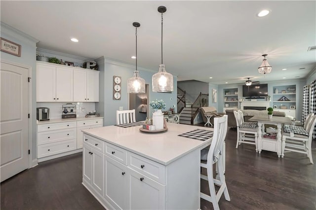 kitchen with light countertops, white cabinets, dark wood-style floors, and hanging light fixtures