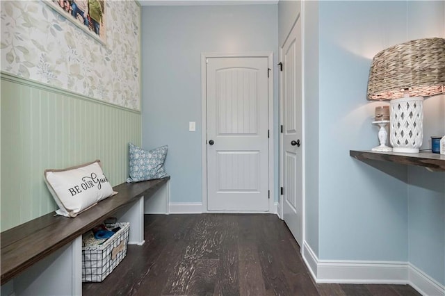 interior space with a wainscoted wall, baseboards, and wood finished floors