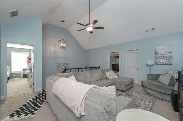 living room featuring high vaulted ceiling, ceiling fan with notable chandelier, visible vents, and light carpet