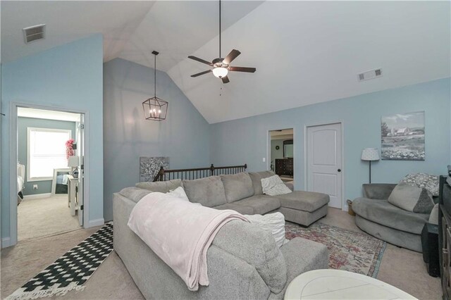 living room featuring ceiling fan with notable chandelier, visible vents, light colored carpet, and high vaulted ceiling