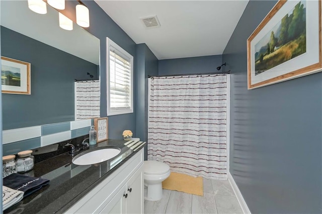 full bathroom featuring vanity, curtained shower, toilet, and visible vents