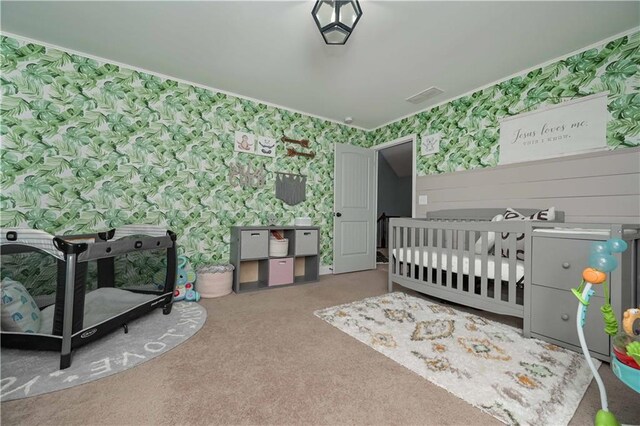 carpeted bedroom featuring wallpapered walls and visible vents