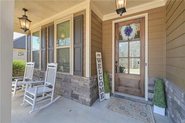 doorway to property with stone siding and a porch