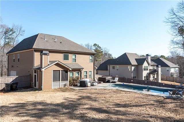 rear view of property with a hot tub, a fenced in pool, a fenced backyard, and a patio area