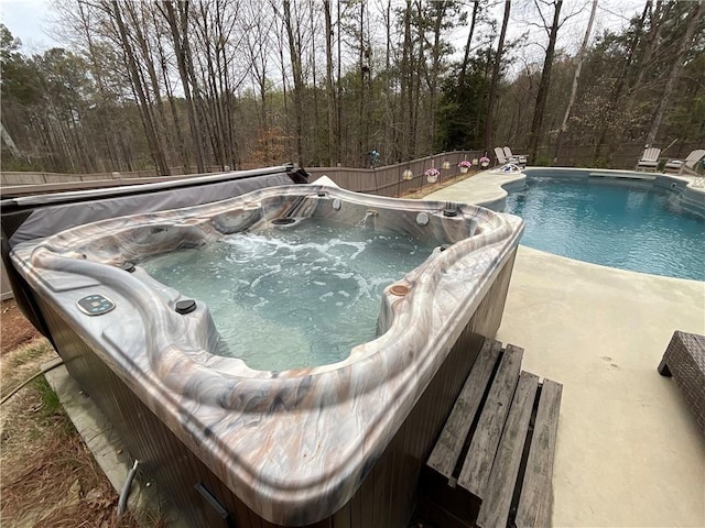view of pool with a hot tub and a fenced in pool