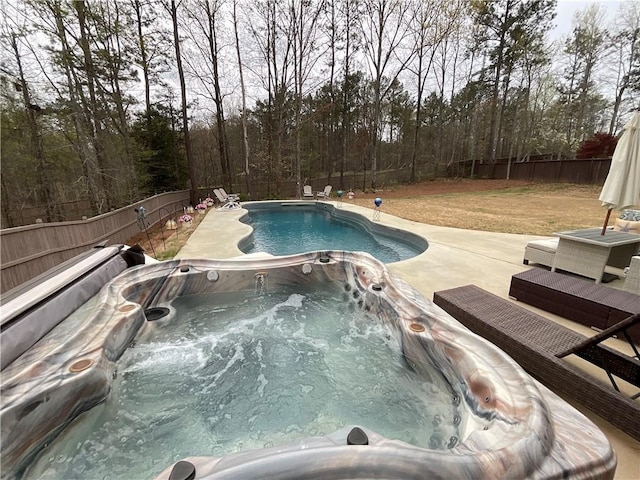 view of pool with a fenced backyard, a patio area, and an outdoor hot tub