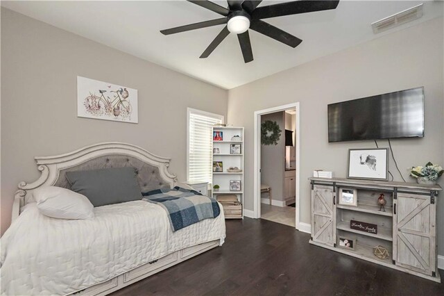 bedroom with baseboards, visible vents, a ceiling fan, ensuite bathroom, and wood finished floors