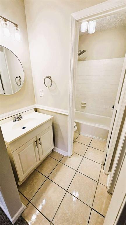 bathroom with vanity, tile patterned flooring, toilet, and tub / shower combination