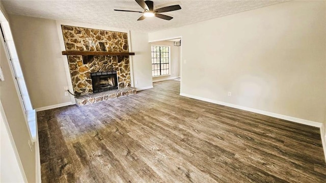 unfurnished living room featuring a ceiling fan, a textured ceiling, a fireplace, wood finished floors, and baseboards