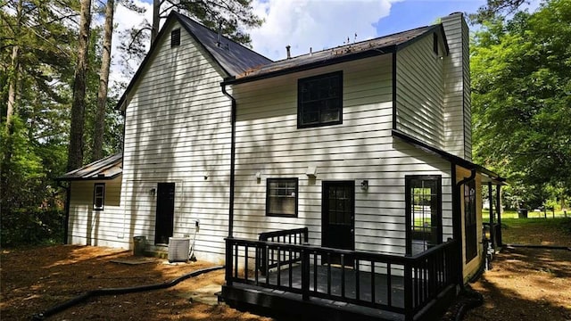 back of house with a chimney and a deck
