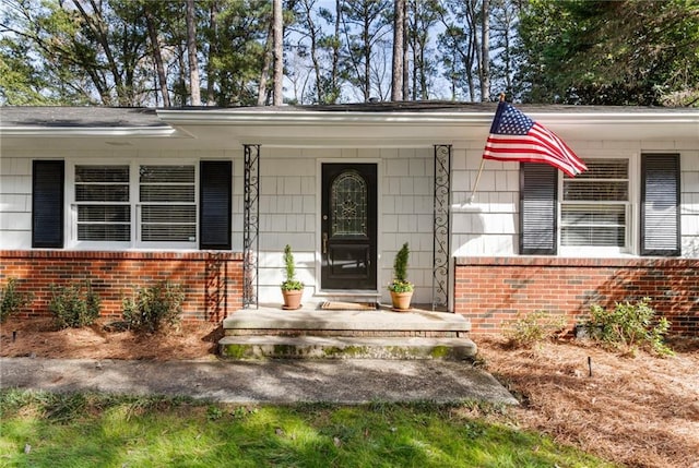 view of exterior entry featuring covered porch