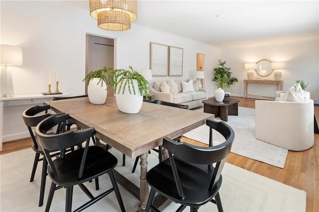 dining room with light hardwood / wood-style floors and a notable chandelier