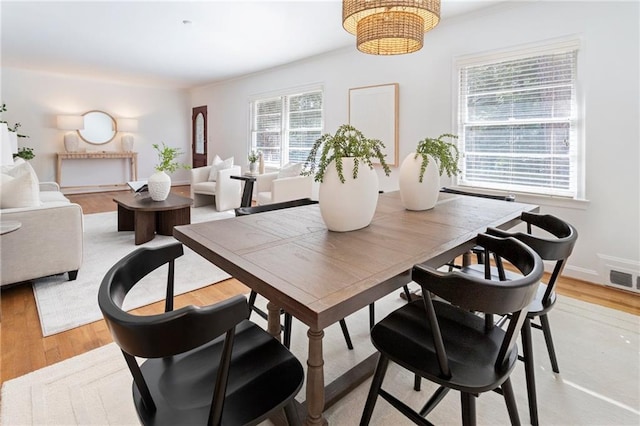 dining area featuring a notable chandelier and light wood-type flooring