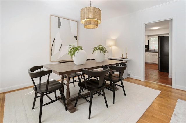 dining room featuring a notable chandelier and light hardwood / wood-style flooring