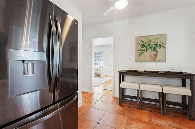 kitchen with light tile patterned floors and stainless steel fridge