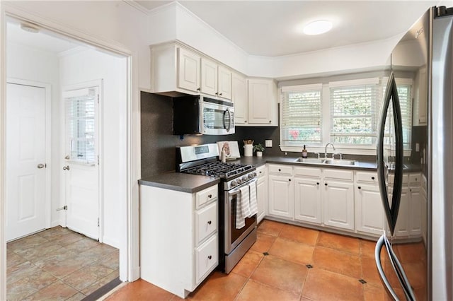 kitchen featuring white cabinetry, sink, a wealth of natural light, and appliances with stainless steel finishes