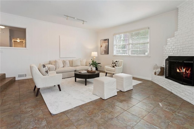 living room with a brick fireplace and track lighting