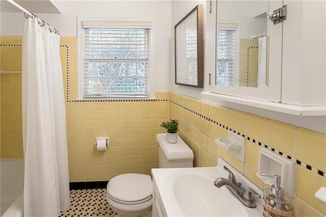 full bathroom with sink, tile walls, shower / bath combo with shower curtain, and toilet