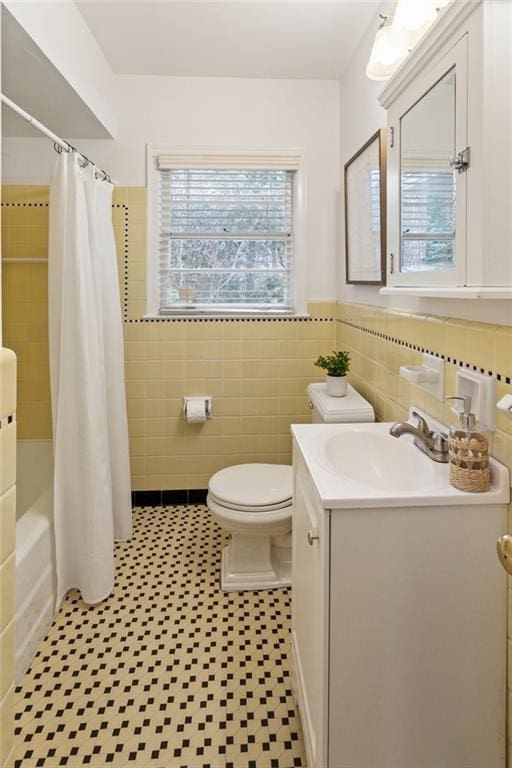 full bathroom featuring vanity, tile walls, toilet, and shower / tub combo with curtain