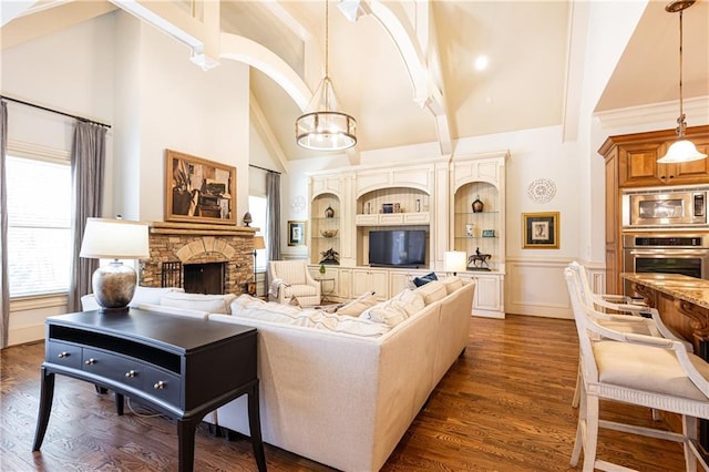 5352 Lacosta Ln, Alpharetta, GA 30022 - living area with high vaulted ceiling, a chandelier, a stone fireplace, built in features, and dark wood-style floors