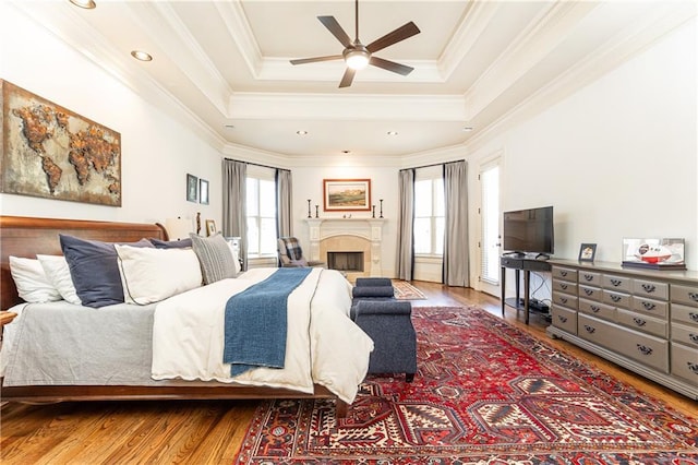 5352 Lacosta Ln, Alpharetta, GA 30022 - bedroom featuring wood finished floors, a tray ceiling, ornamental molding, a fireplace, and recessed lighting
