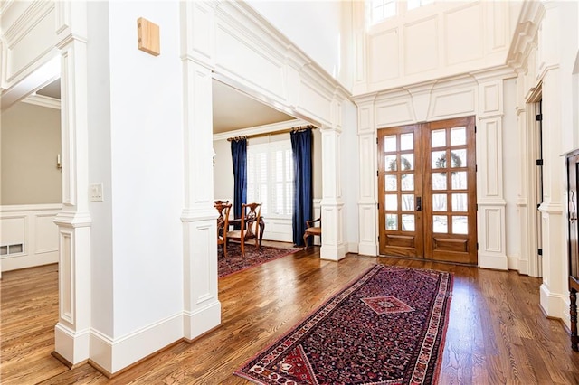 5352 Lacosta Ln, Alpharetta, GA 30022 - foyer entrance with a decorative wall, wood finished floors, decorative columns, ornamental molding, and wainscoting