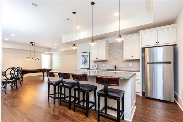 5352 Lacosta Ln, Alpharetta, GA 30022 - kitchen with freestanding refrigerator, a kitchen island, tasteful backsplash, dark wood finished floors, and a kitchen bar