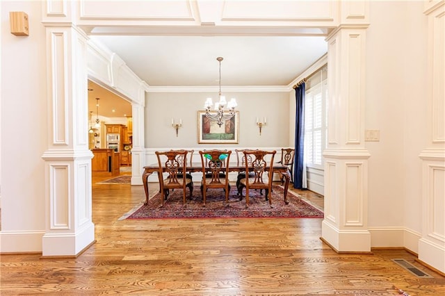 5352 Lacosta Ln, Alpharetta, GA 30022 - dining space featuring decorative columns, light wood-type flooring, a chandelier, ornamental molding, and a decorative wall