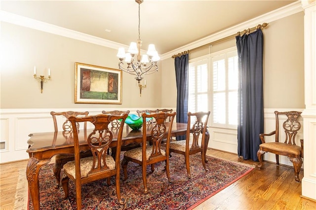 5352 Lacosta Ln, Alpharetta, GA 30022 - dining area with crown molding, a chandelier, a wainscoted wall, a decorative wall, and light wood-style flooring