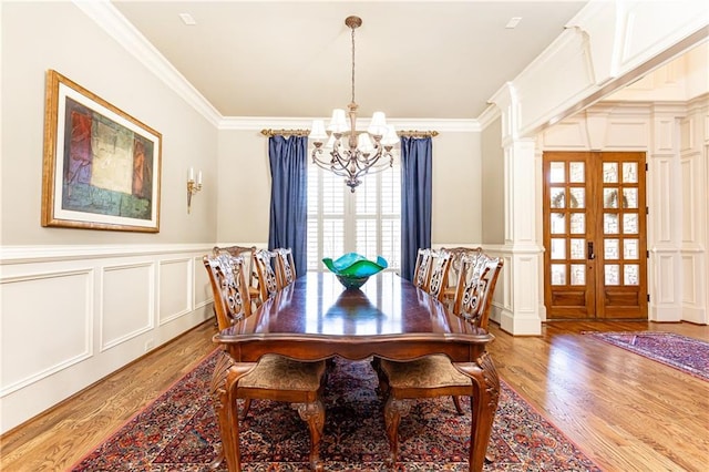 5352 Lacosta Ln, Alpharetta, GA 30022 - dining room featuring a chandelier, wood finished floors, ornamental molding, a decorative wall, and ornate columns