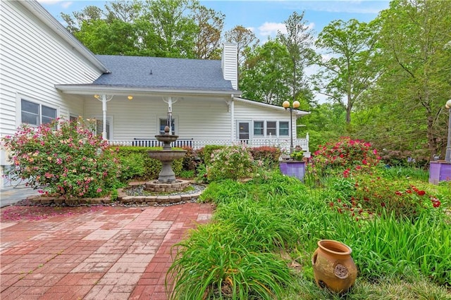 rear view of property featuring a chimney