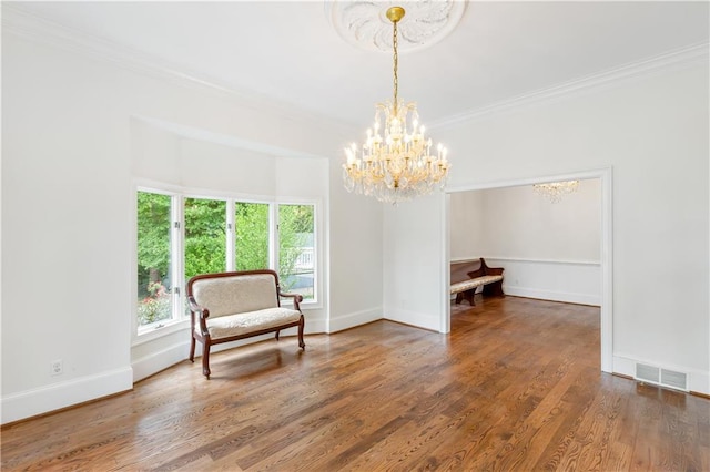 sitting room featuring crown molding, a chandelier, baseboards, and visible vents