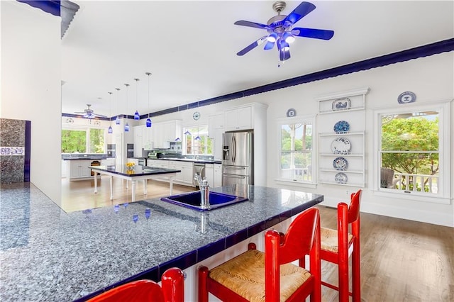 kitchen featuring dark countertops, appliances with stainless steel finishes, ceiling fan, and white cabinetry