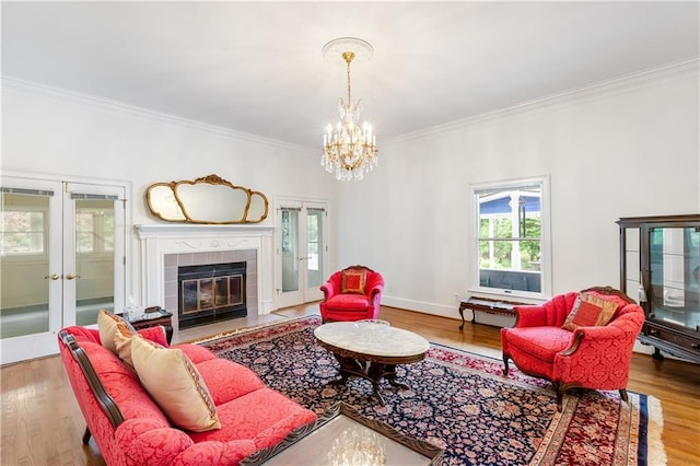 living room with ornamental molding, french doors, wood finished floors, and a notable chandelier