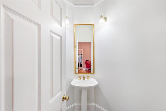 bathroom featuring baseboards and ornamental molding