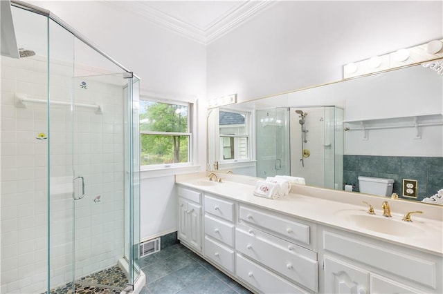bathroom with tile patterned flooring, a sink, a shower stall, and ornamental molding