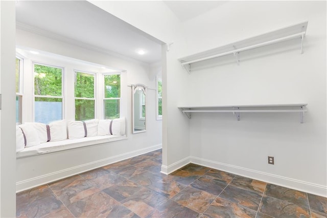 walk in closet featuring stone finish floor