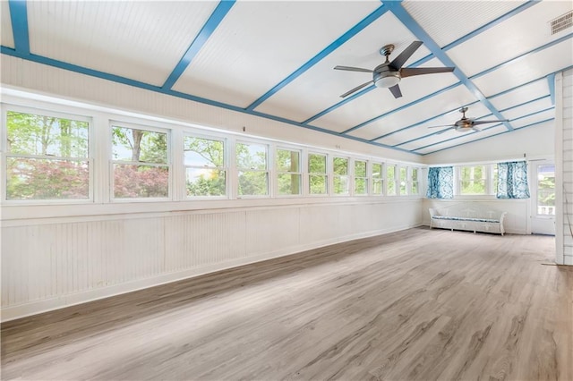 unfurnished sunroom featuring vaulted ceiling, wood finished floors, and visible vents