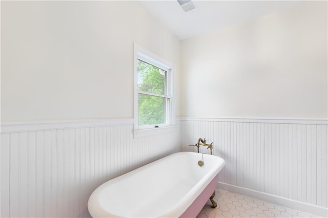 bathroom with visible vents, tile patterned floors, wainscoting, and a freestanding bath
