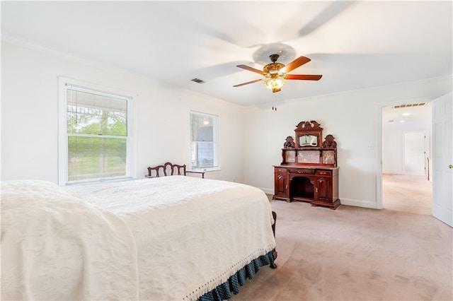 bedroom with ornamental molding, a ceiling fan, light colored carpet, and visible vents